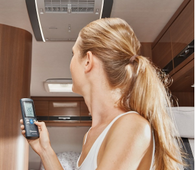 Lady holding a phone inside a motorhome